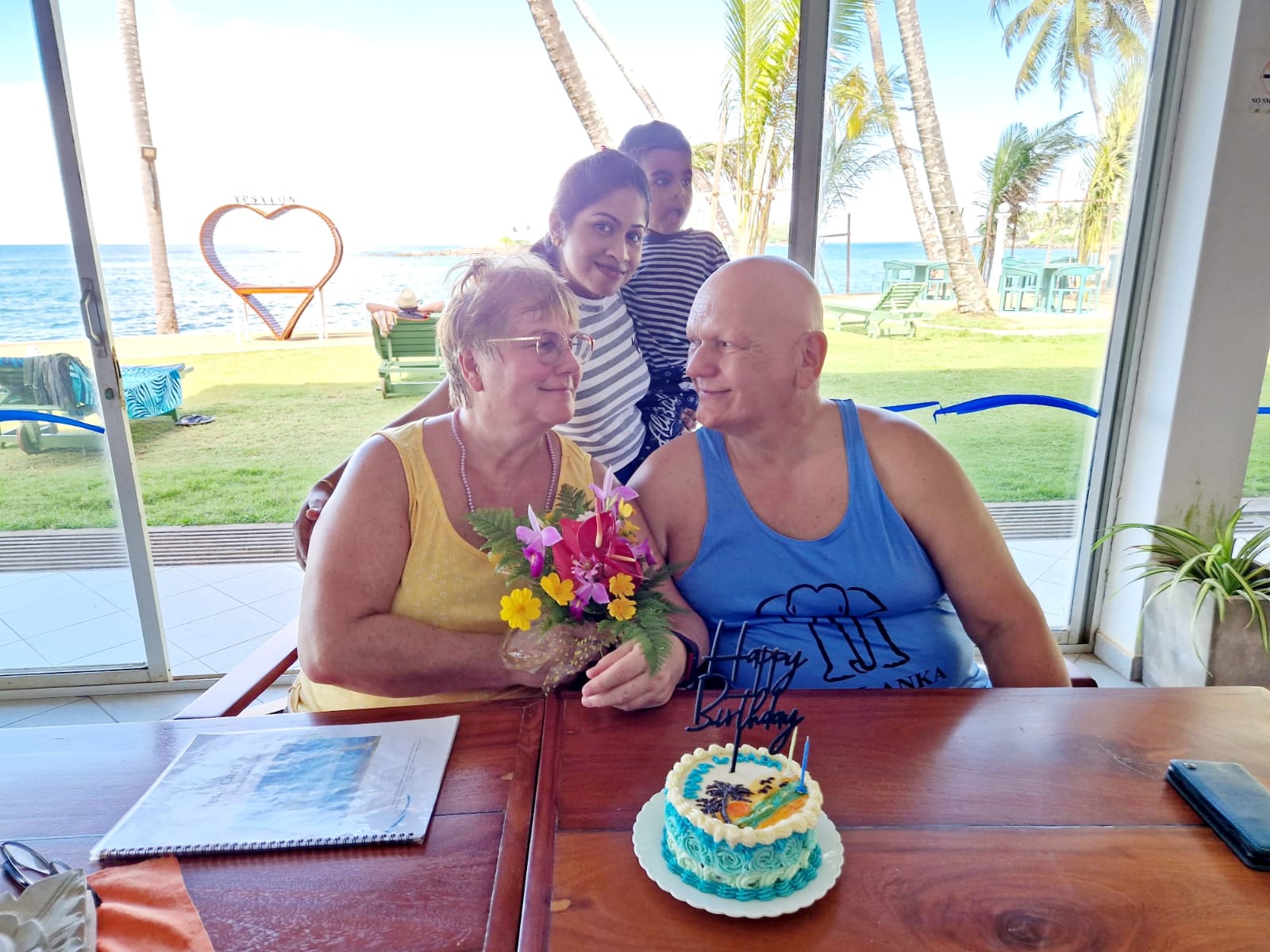 Guests and local hosts sharing a birthday celebration by the beach