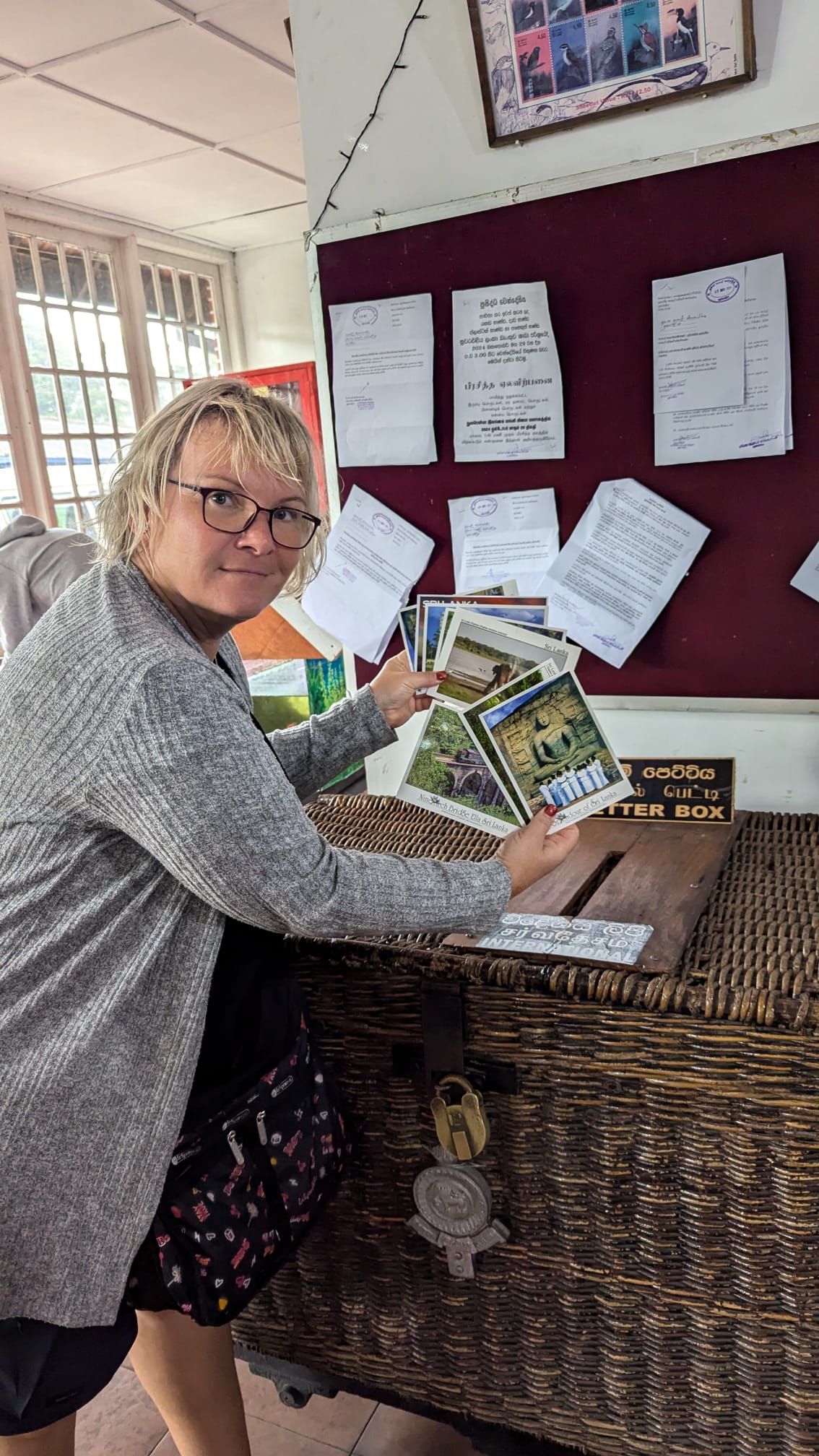 A guest choosing postcards at a traditional Sri Lankan post office