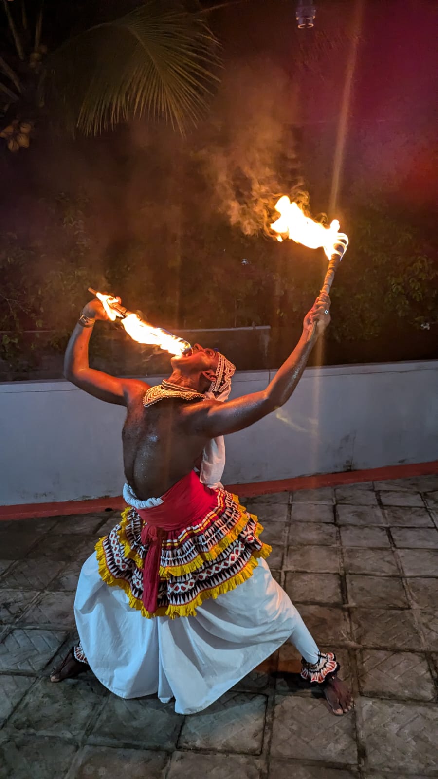 A Sri Lankan cultural performer presenting a dramatic traditional fire act