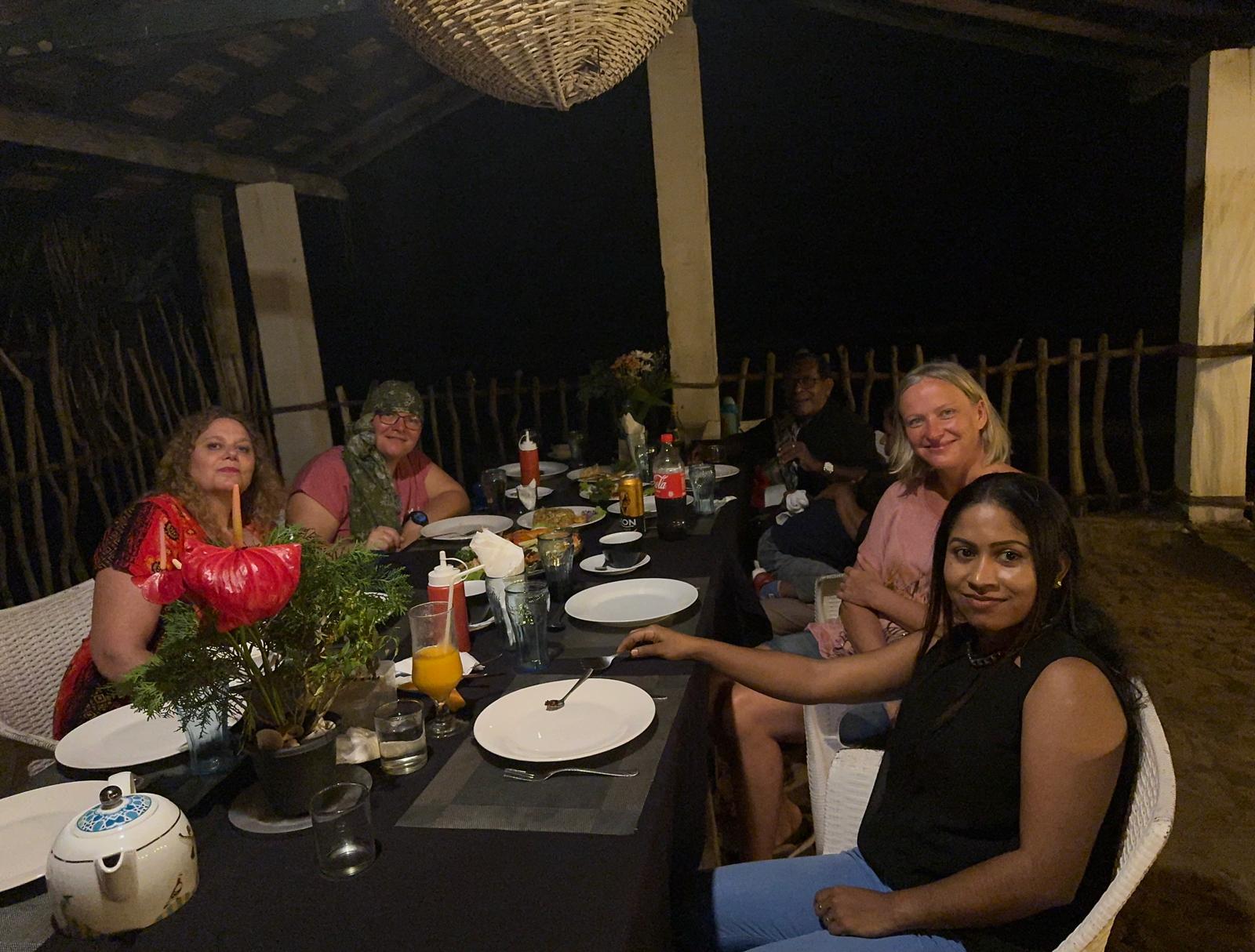 Guests and their local host sharing dinner after a day of touring Sri Lanka
