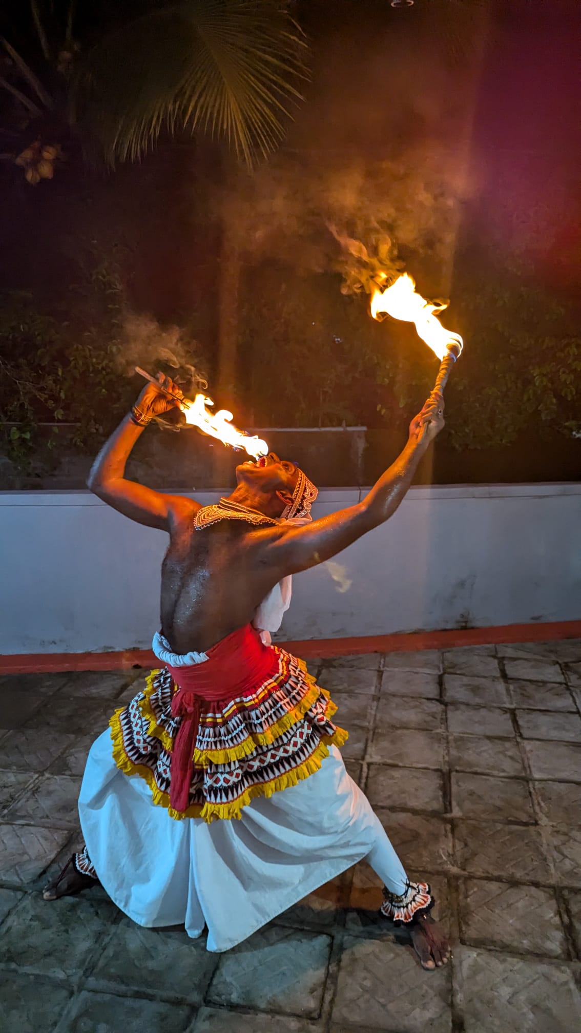 Traditional Sri Lankan fire dancer performing for guests during an evening show