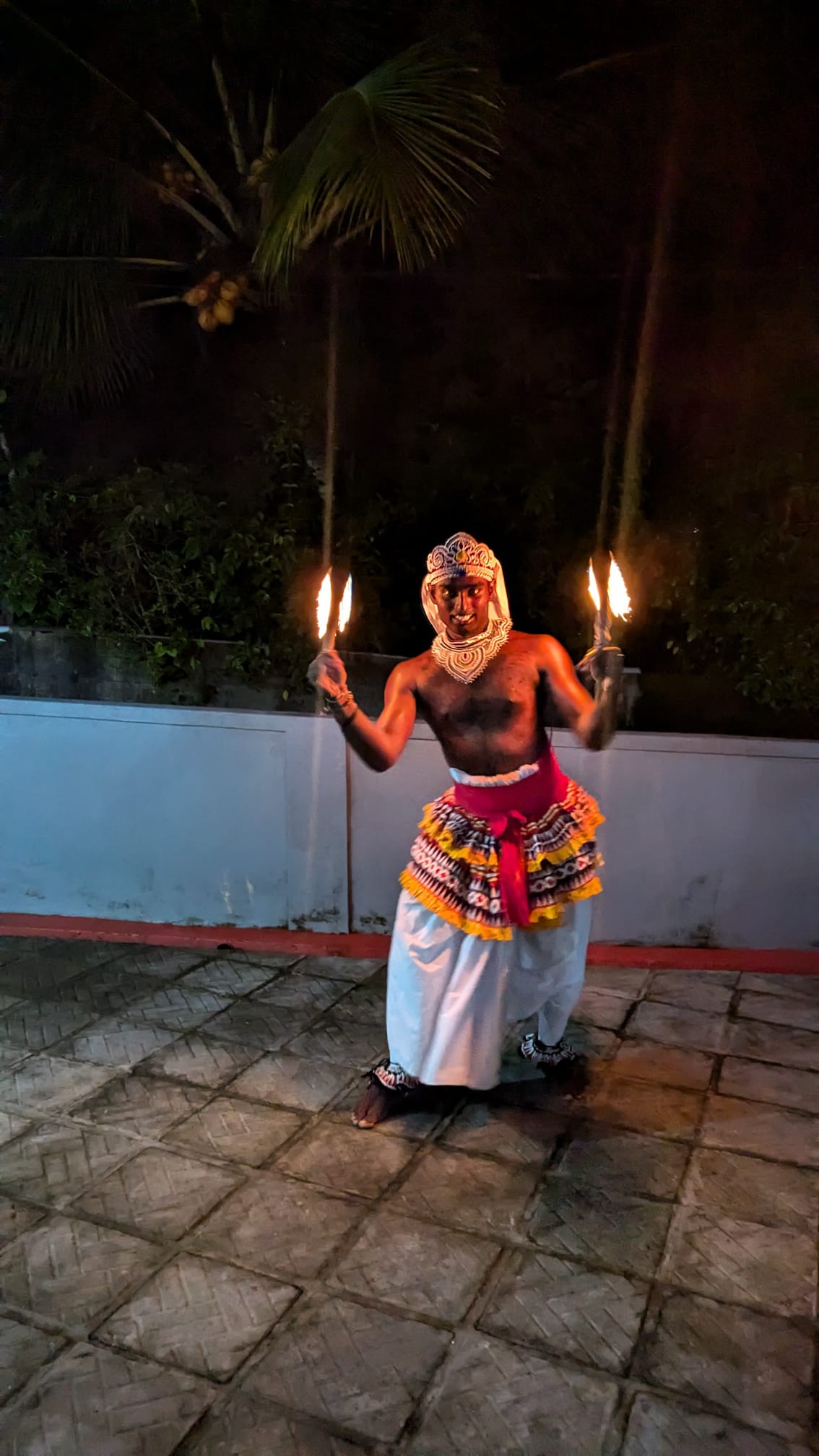 A traditional performer holding fire torches during a Sri Lankan cultural show