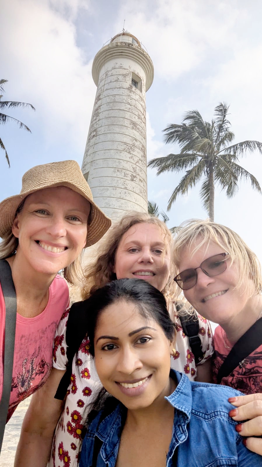A smiling group selfie with guests and their guide at Galle Fort lighthouse